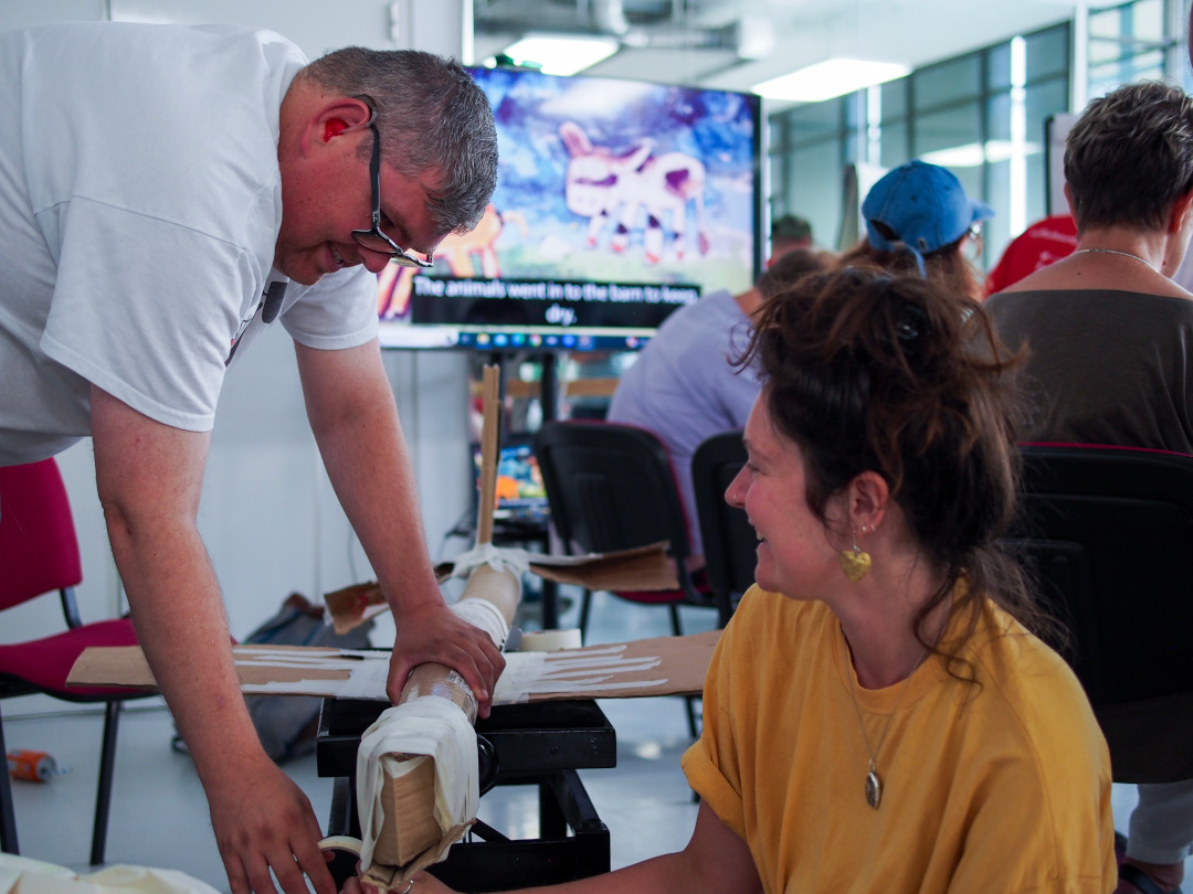 Two artists working on a sculpture using recycled materials