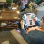 A view over a person's shoulder as she she reads an article in a football programme