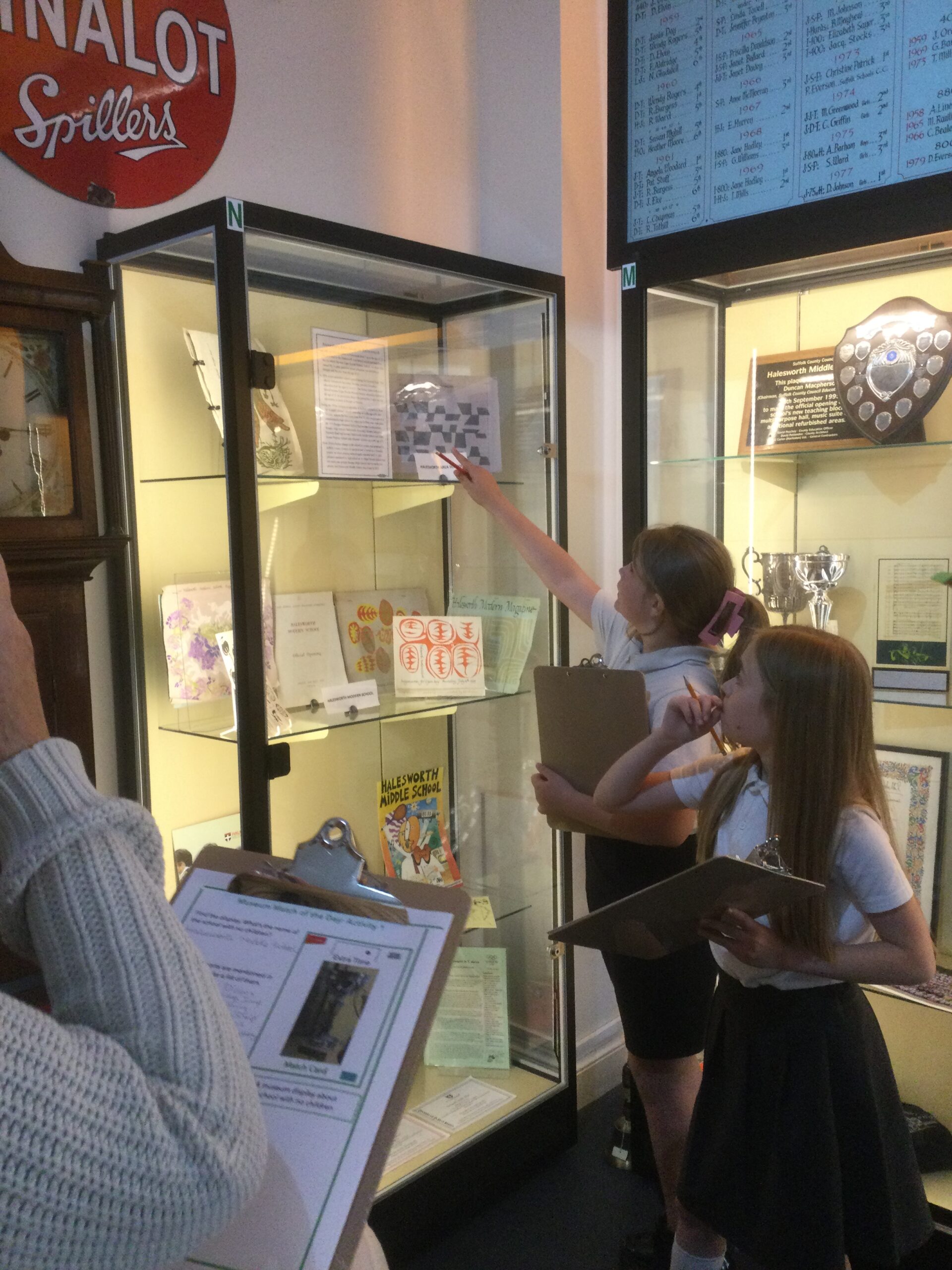 Two school girls pointing to an exhibit in a display case