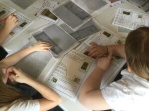 Overhead view of school children surrounded by printed papers and worksheets