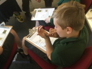 A school boy closely examining a medallion