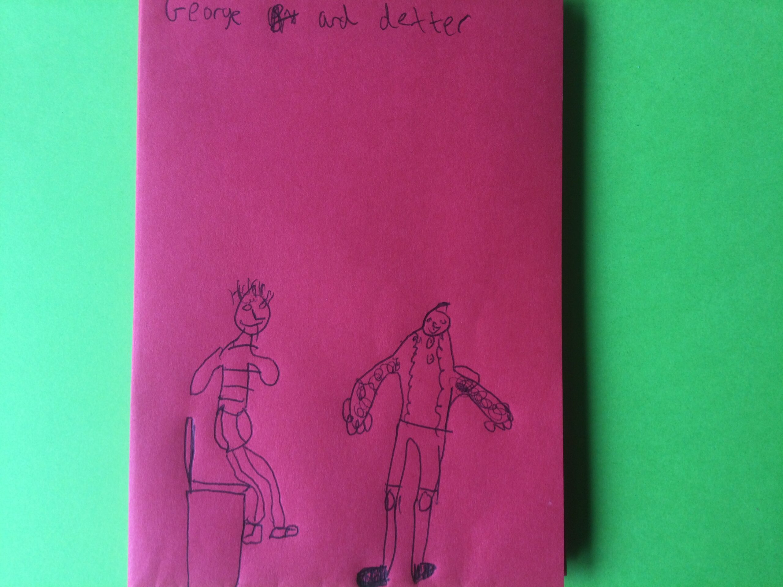 A pink paper booklet with two hand-drawn figures on the cover and the names George and Dexter above