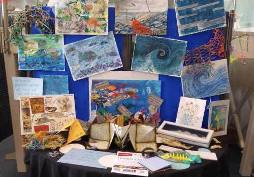 A display of artwork from Suffolk Artlink's Curious Minds programme. Many of the works feature images of the sea.