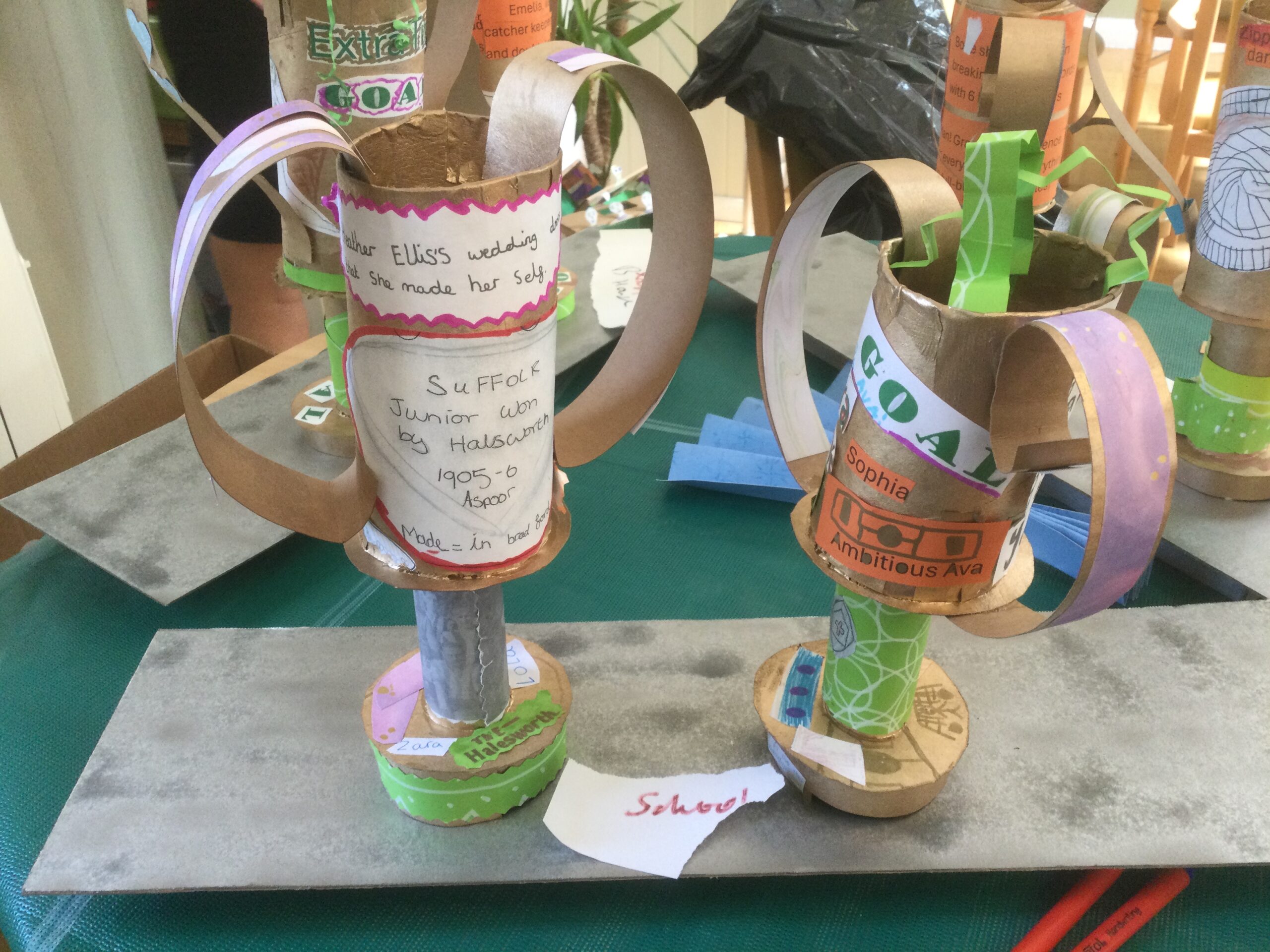 Two decorated gold trophies on a silver plinth, for the school