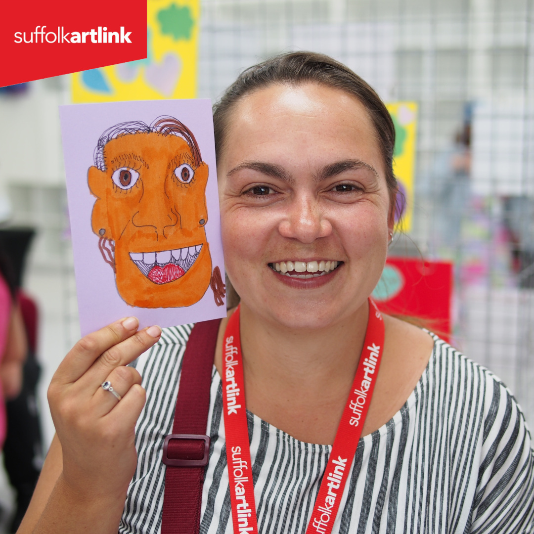 woman holding postcard portrait to her face for comparison.