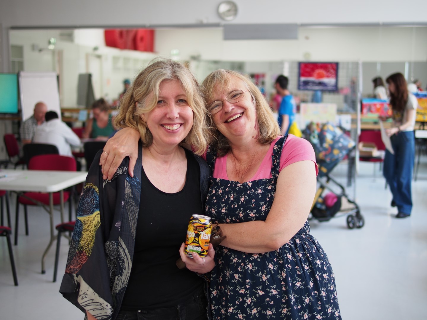 two women smiling with their arms about each other's shoulders,