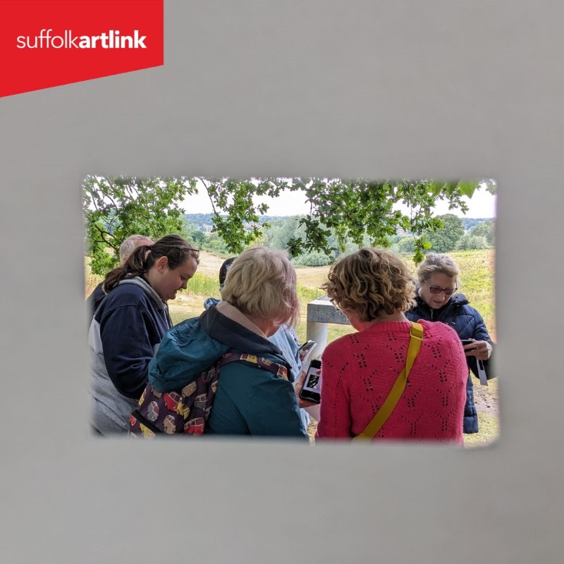 Workshop participants framed by a handheld rectangular cardboard frame