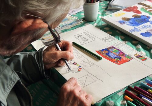 Participant working on artwork using fine felt tip pens.