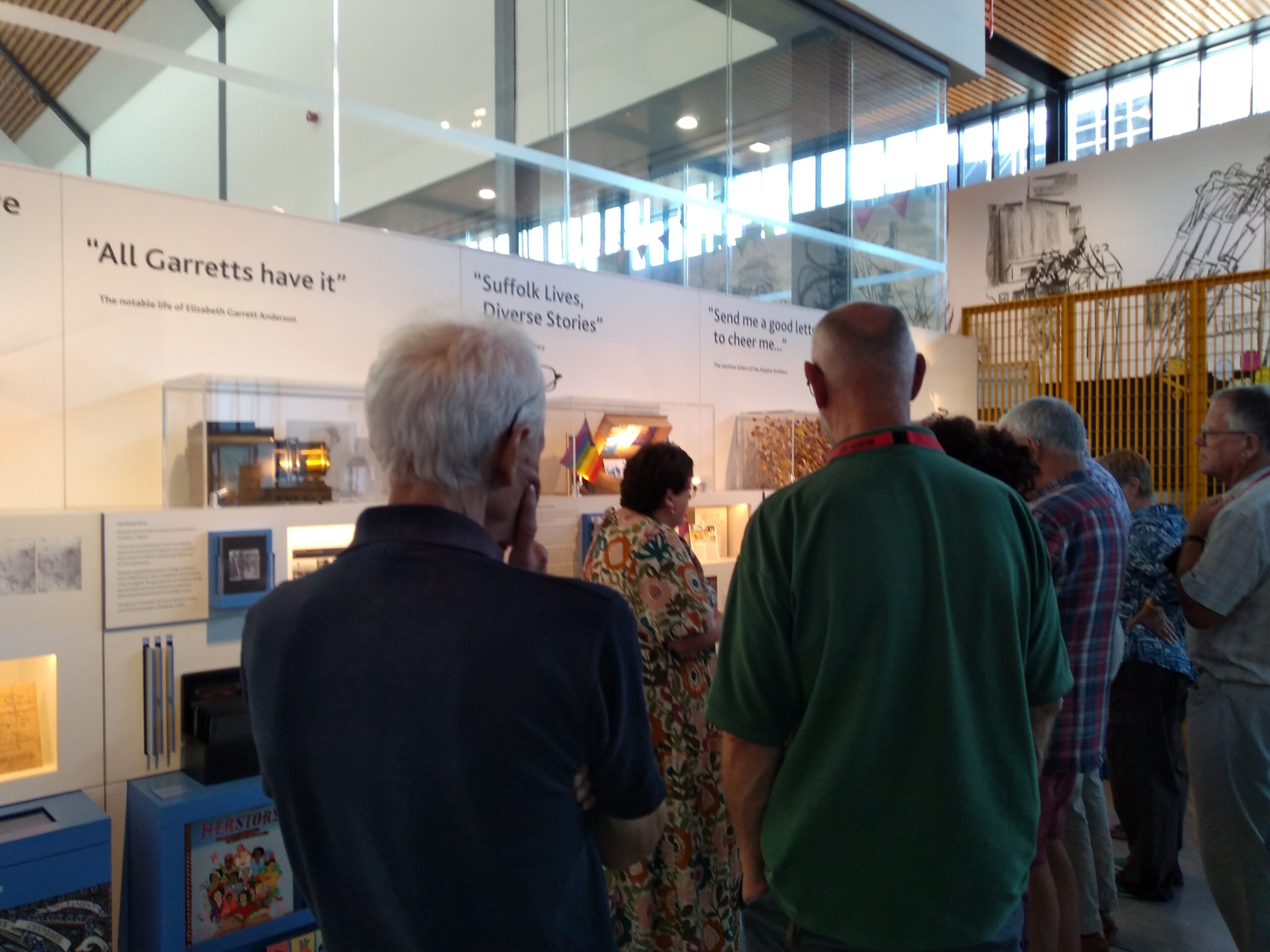 A group of adults looking at an Archive display of local stories and characters