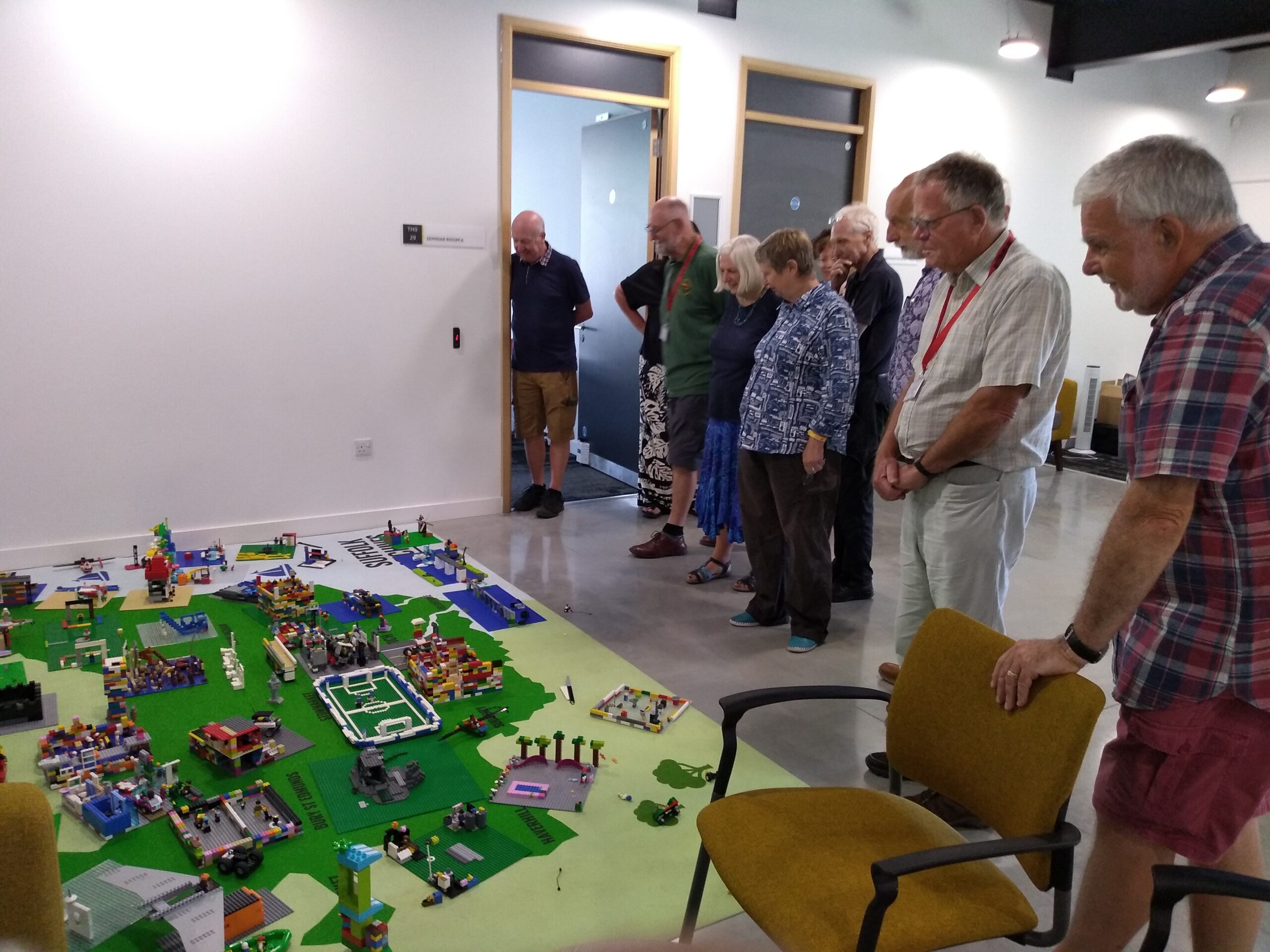 A group of adults looking a model made out of Lego, depicting significant areas in Suffolk