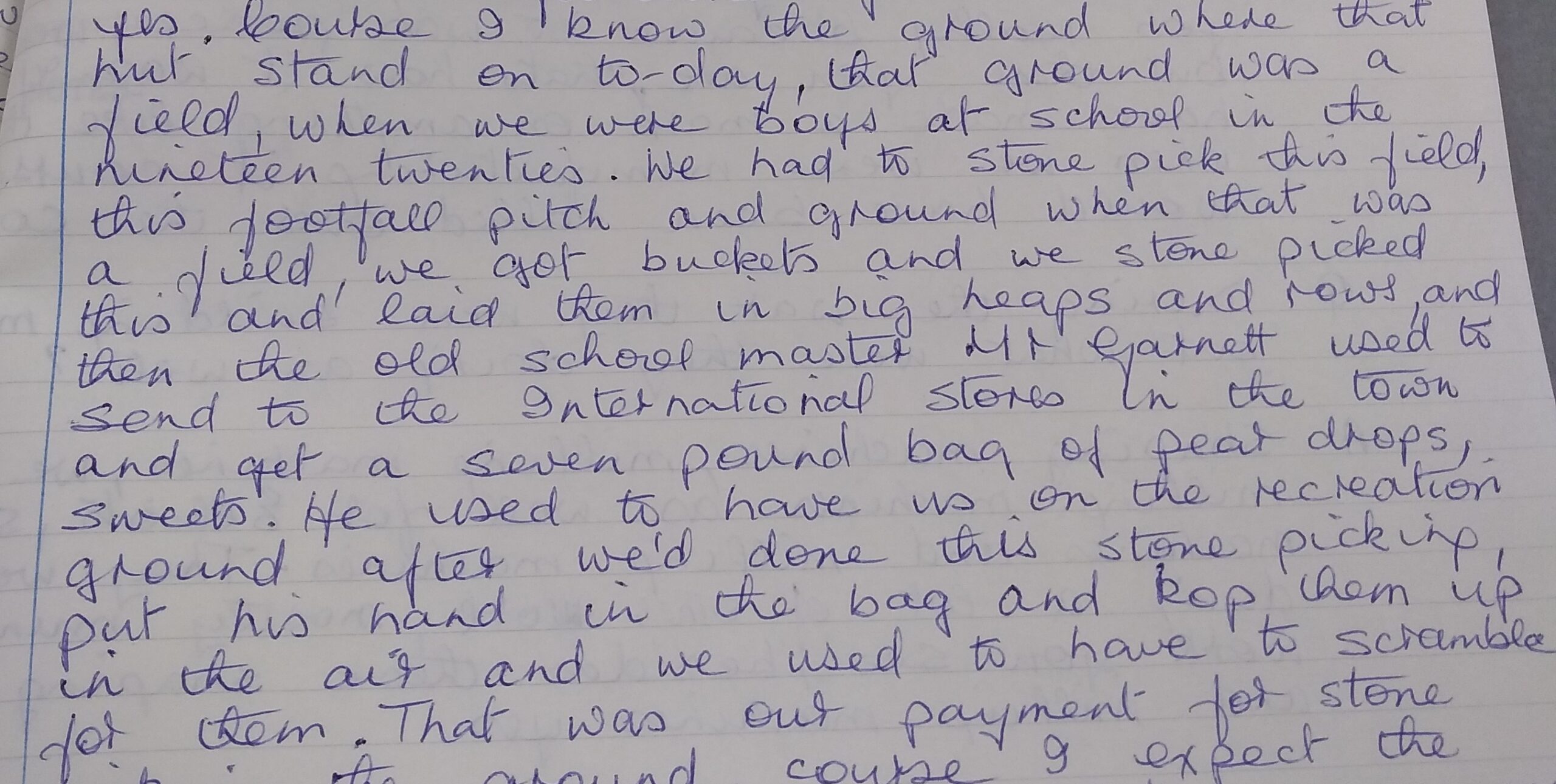 An extract from a transcribed oral history tape in which the speaker describes picking up stones from the field that was to be made into a football pitch and then the primary school teacher, Mr Garnett going to the International Stores in the town and buying a seven pound bag of pear drop sweets which he'd throw up into the air and the children had to scramble to get them