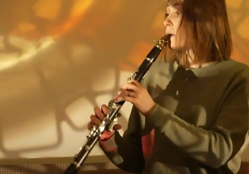 Clarinet player in front of an abstract projection.