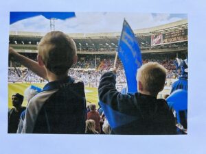 Kids waving flags at a match