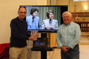 Steve Prentice and Paul Browes in front of TV showing them on FA Cup Mastermind