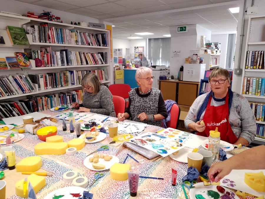 people sitting at a table print making.