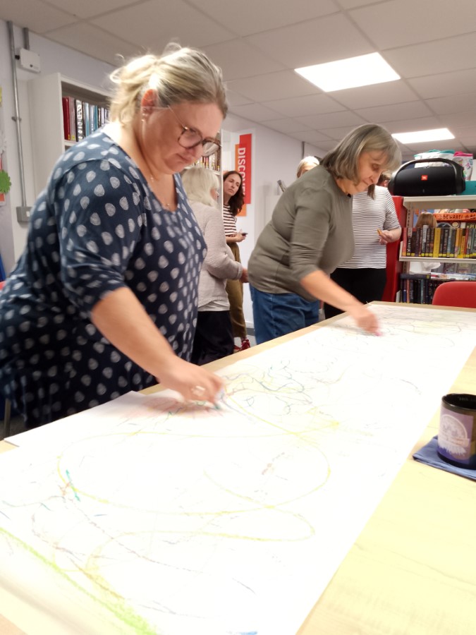 women mark making on a large sheet of lining paper