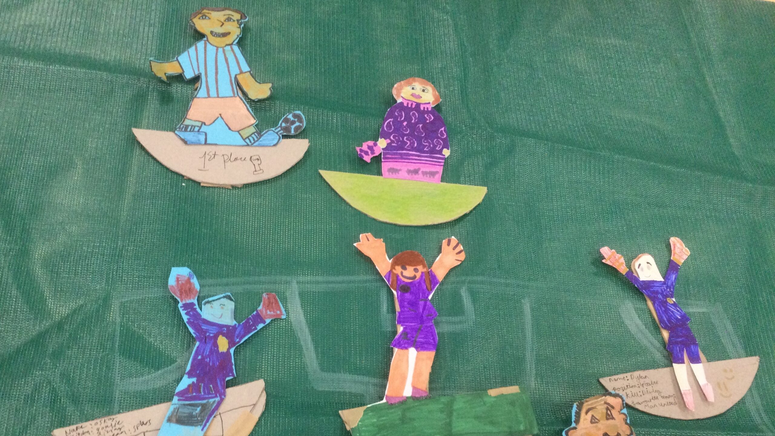 An assortment of cut-out football figures on a green background