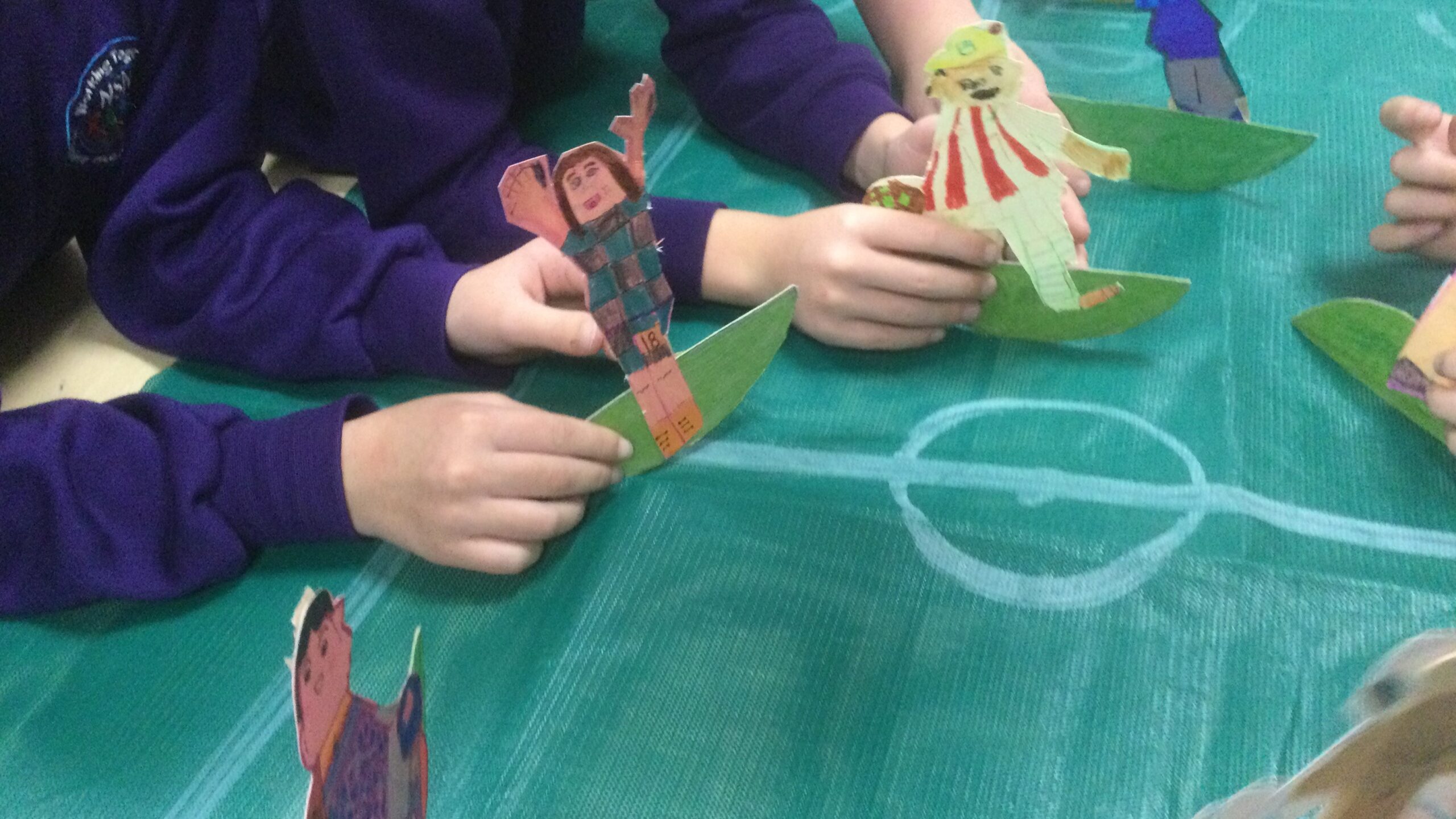 Football figures held by the children on a green 'pitch'