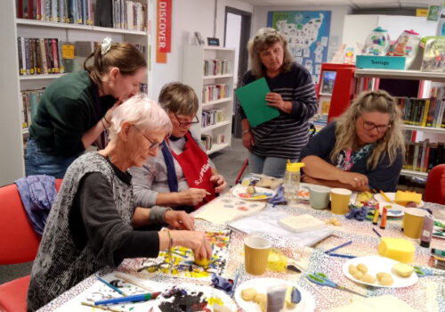 people sitting at a table print making.