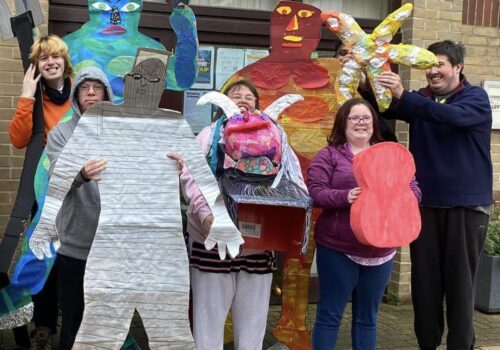 Brave Art students holding their people sized sculptures