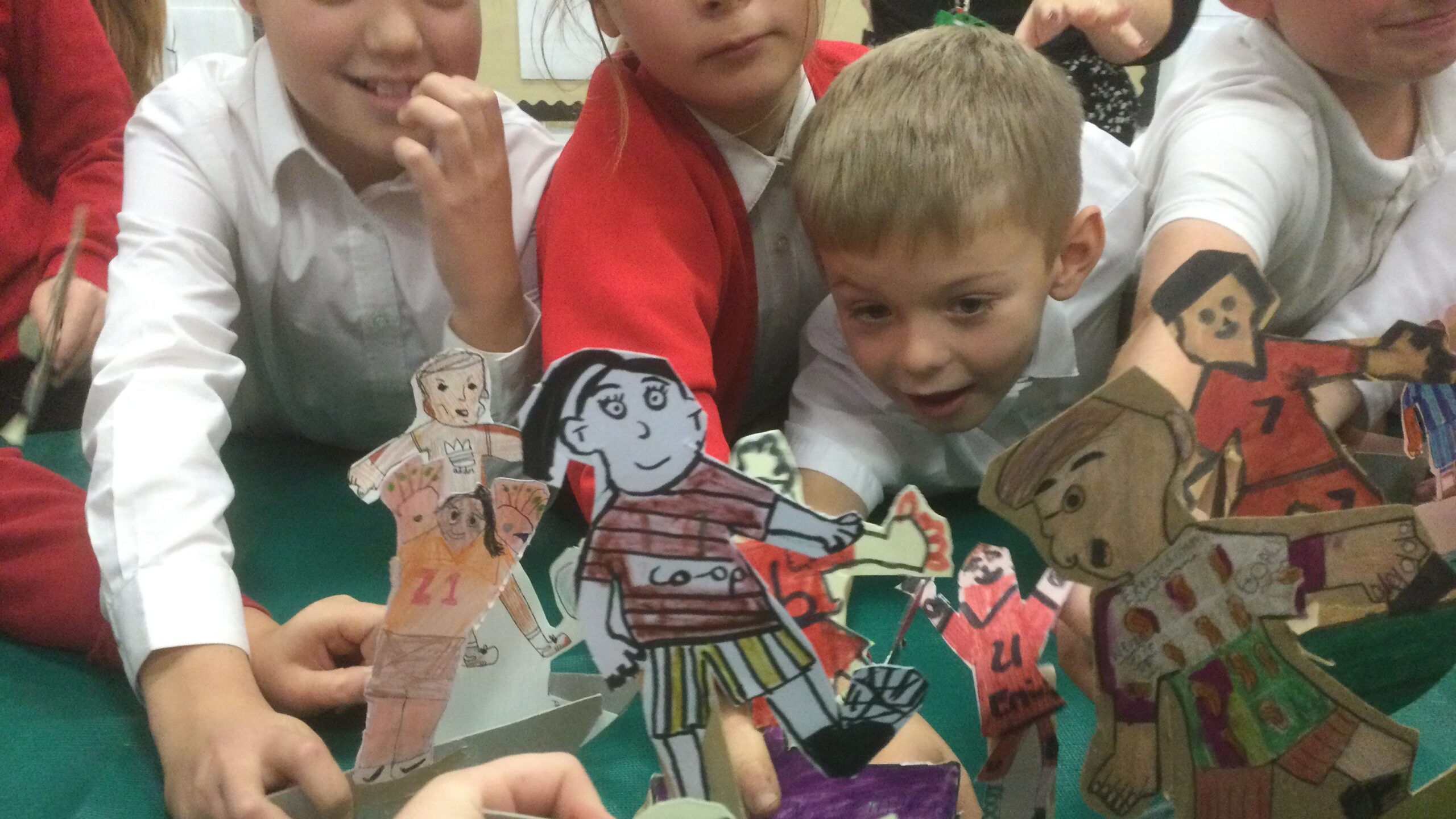 A cluster of school children, each holding a cardboard football figure on the table