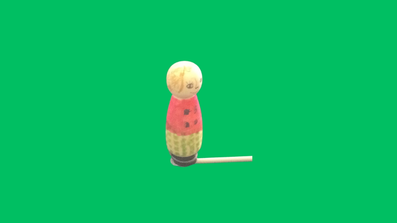 A wooden figure with red top and green patterned trousers